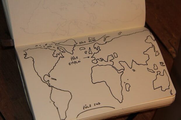Un carnet avec une carte du monde dessinée. Trois points sont indiqués : pôle nord, pôle sud, pôle emploi.
