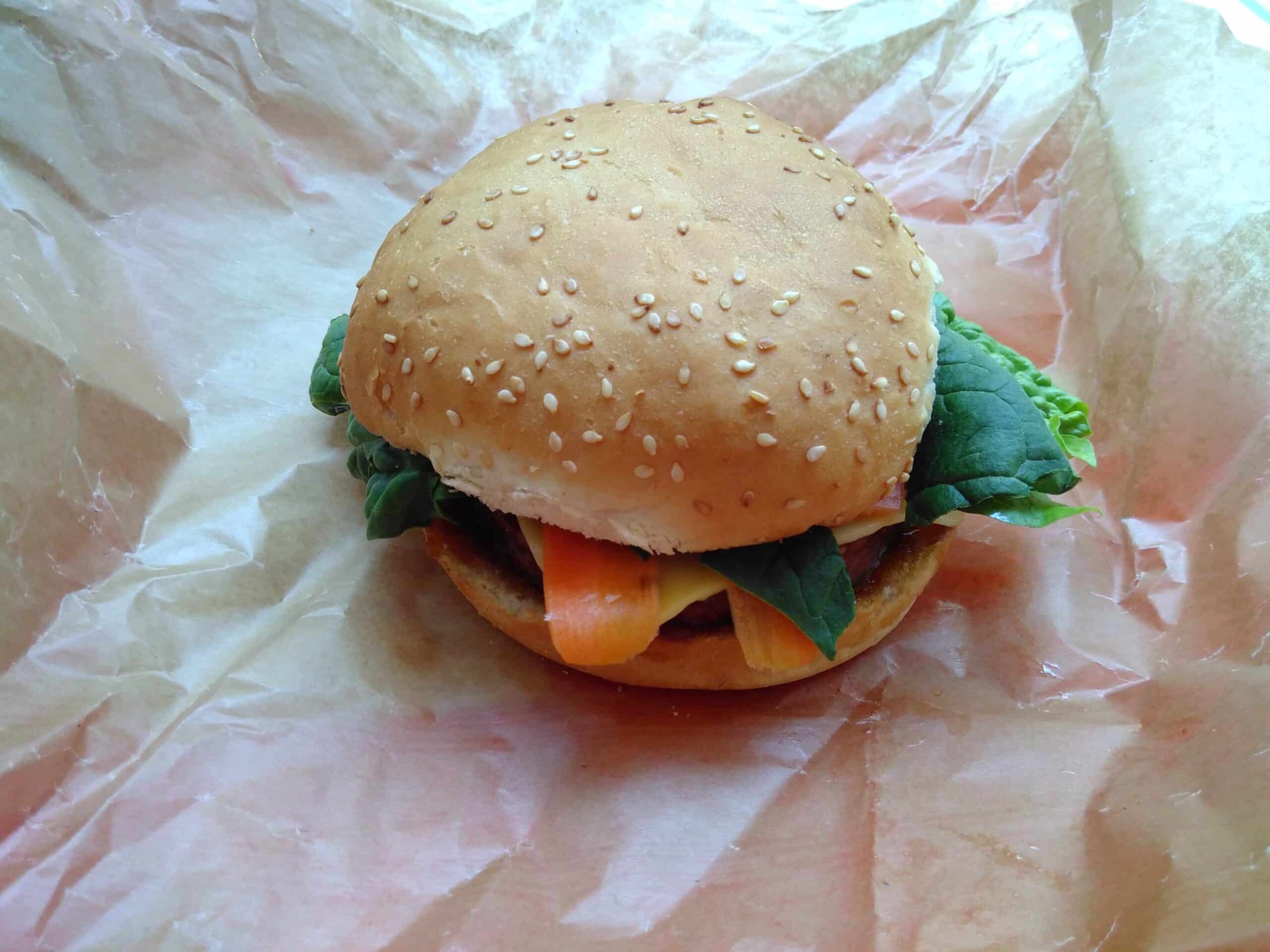 Un burger vu de dessus, la photo est peu informative et la lumière est très froide.