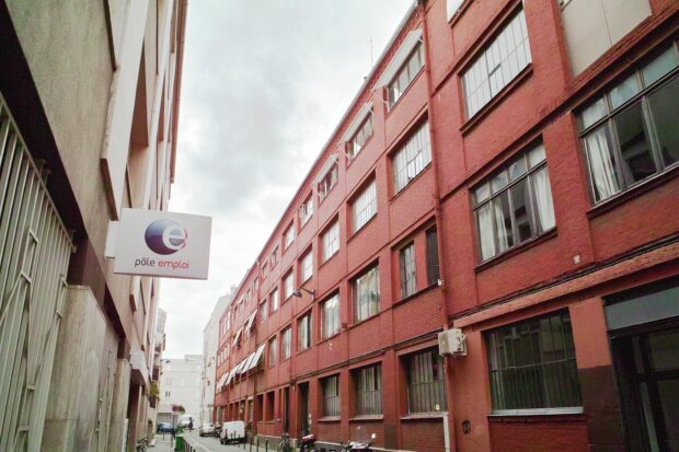 L'enseigne d'un Pôle emploi, face à une ex-usine en briques rouges.