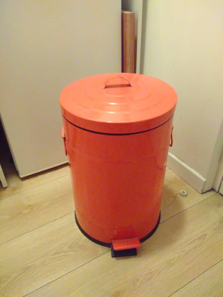 Une poubelle à pédale orange.